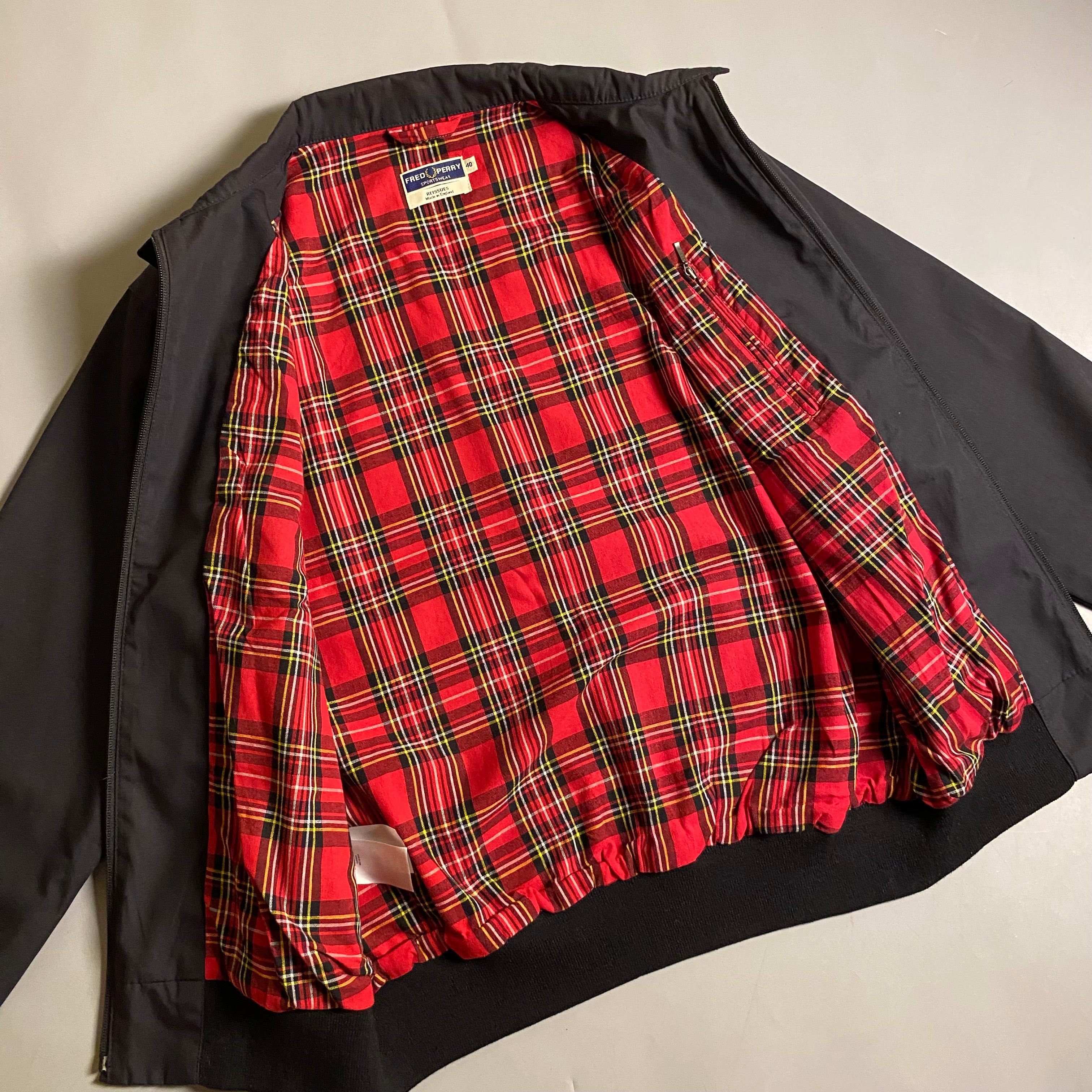 Fred Perry Made In England Harrington Jacket in black with a red tartan lining